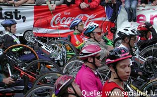 Mehrere Mobilitätsbehinderte bereiten sich in der abbildung auf den Start eines  Handbike Rennens vor.